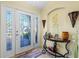 Inviting foyer with decorative glass door, a stylish accent table, and neutral color palette at 4571 Abaco Dr, Tavares, FL 32778