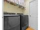 Convenient laundry room features a modern washer and dryer set and upper shelving for storage at 4571 Abaco Dr, Tavares, FL 32778