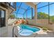 Unique pool boasts an integrated rock feature and clear, refreshing water in screened in patio at 4571 Abaco Dr, Tavares, FL 32778