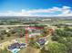 Aerial view of a home on an expansive lot in a pastoral setting with mature trees and distant views at 464 Long & Winding Rd, Groveland, FL 34736