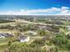 Aerial view showcases the property's expansive acreage with wooded areas near a developed area at 464 Long & Winding Rd, Groveland, FL 34736