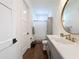 Stylish bathroom with gold fixtures, gray cabinets, white marble countertops, and wood-look flooring at 464 Long & Winding Rd, Groveland, FL 34736