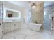 Elegant bathroom features a soaking tub, decorative wall, and walk-in shower at 464 Long & Winding Rd, Groveland, FL 34736