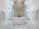Luxurious bathroom featuring a freestanding tub and dual walk-in shower with gold accents at 464 Long & Winding Rd, Groveland, FL 34736