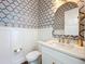 Charming powder room with decorative wallpaper, marble counters, gold fixtures and elegant finishes at 464 Long & Winding Rd, Groveland, FL 34736