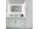 Bright bathroom with white cabinets, dual sinks, marble countertops, and illuminated mirror at 464 Long & Winding Rd, Groveland, FL 34736