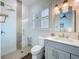 Stylish bathroom featuring a glass-enclosed shower and a vanity with gold hardware at 464 Long & Winding Rd, Groveland, FL 34736