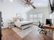 Comfortable bedroom featuring a desk, ceiling fan, and natural light from the shuttered windows at 464 Long & Winding Rd, Groveland, FL 34736