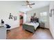Bedroom with hardwood floors, ceiling fan, and windows with plantation shutters at 464 Long & Winding Rd, Groveland, FL 34736