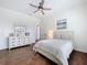 Comfortable bedroom with hardwood floors, a dresser, and a large window at 464 Long & Winding Rd, Groveland, FL 34736