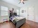 Cozy bedroom with wood floors, shuttered windows, and neutral grey decor at 464 Long & Winding Rd, Groveland, FL 34736