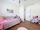 Bright bedroom with hardwood floors, a ceiling fan, and a window with plantation shutters at 464 Long & Winding Rd, Groveland, FL 34736