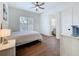 Bright bedroom with hardwood floors, plantation shutters, and an ensuite bathroom at 464 Long & Winding Rd, Groveland, FL 34736