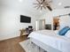 Bright main bedroom boasts high ceilings, a ceiling fan, wood beam, and a dedicated closet at 464 Long & Winding Rd, Groveland, FL 34736