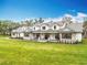 Stunning two-story farmhouse with a metal roof, stone accents, dormer windows, and a welcoming front porch at 464 Long & Winding Rd, Groveland, FL 34736