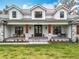 Charming two-story farmhouse featuring a metal roof, stone accents, dormer windows, and a welcoming front porch at 464 Long & Winding Rd, Groveland, FL 34736