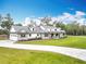 Beautiful exterior of a two-story home with lush green lawn, brick accents and circular driveway at 464 Long & Winding Rd, Groveland, FL 34736