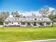 Charming, white farmhouse-style home with a metal roof, stone accents, and a lush green lawn at 464 Long & Winding Rd, Groveland, FL 34736