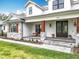 Inviting front porch features wooden columns, stone accents, and a seating area, enhancing curb appeal at 464 Long & Winding Rd, Groveland, FL 34736
