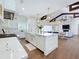 Spacious open kitchen with an island, white cabinetry, and views into the living and dining areas at 464 Long & Winding Rd, Groveland, FL 34736