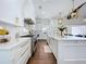 Beautiful white kitchen featuring marble countertops, stainless steel appliances, and hardwood floors at 464 Long & Winding Rd, Groveland, FL 34736