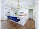 Bright open kitchen offers a marble countertop island with seating, modern lighting, and stainless appliances at 464 Long & Winding Rd, Groveland, FL 34736