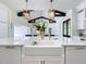 Close-up of a modern kitchen island with a farmhouse sink, gold hardware, and elegant countertops at 464 Long & Winding Rd, Groveland, FL 34736