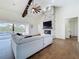 Cozy living room featuring a stone fireplace, wood floors, high ceilings, and sliding glass doors to the pool area at 464 Long & Winding Rd, Groveland, FL 34736