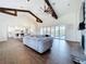 Spacious living room featuring hardwood floors, vaulted ceilings with wood beams, and large sliding doors to outdoor pool at 464 Long & Winding Rd, Groveland, FL 34736