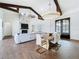 Open concept living room featuring a fireplace, exposed beams, and modern dining area at 464 Long & Winding Rd, Groveland, FL 34736