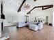 Spacious living room featuring wood floors, vaulted ceilings, exposed beams, and an open layout at 464 Long & Winding Rd, Groveland, FL 34736