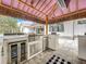 Covered outdoor kitchen features a stainless steel grill, refrigerator, and an attached wine cooler at 464 Long & Winding Rd, Groveland, FL 34736