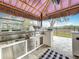 Outdoor kitchen featuring stainless steel appliances, including a built-in grill and ample counter space at 464 Long & Winding Rd, Groveland, FL 34736