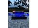 Modern pool with blue lighting, water features, and fire bowls for evening ambiance at 464 Long & Winding Rd, Groveland, FL 34736