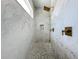 Modern shower features marble-look tile, gold fixtures, and a pebble floor at 464 Long & Winding Rd, Groveland, FL 34736