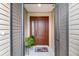 Inviting front door area with a screen door, stylish door mat, and an attractive potted plant at 5510 Thome Loop, The Villages, FL 32163