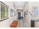 Bright hallway featuring stylish wood-look flooring, decorative art, and a modern lighting fixture at 5510 Thome Loop, The Villages, FL 32163