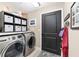 Laundry room with modern washer and dryer, storage shelves, and neutral decor at 5510 Thome Loop, The Villages, FL 32163