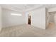 Bright bedroom featuring neutral walls, a tray ceiling, and a hallway with a bathroom at 5675 Herman Ave, The Villages, FL 32163