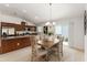 Bright dining area features a modern chandelier, a wood table, and sliding glass doors to the backyard at 5675 Herman Ave, The Villages, FL 32163