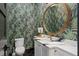 Powder room with designer wallpaper and round mirror at 60 N Park Ave, Winter Garden, FL 34787