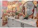 Bright bathroom features double vanity, modern wallpaper, and circular mirrors at 60 N Park Ave, Winter Garden, FL 34787