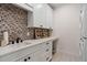 Laundry room featuring custom cabinetry, mosaic backsplash and tile floor at 60 N Park Ave, Winter Garden, FL 34787