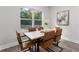 Modern dining room featuring a wood table, stylish chairs, and a bright window with a view of the outside at 7267 Sw 128Th Terrace Rd, Dunnellon, FL 34432
