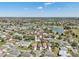 Sweeping aerial shot showcases a neighborhood with manicured lawns, mature trees, and a picturesque pond and golf course at 750 Evelynton Loop, The Villages, FL 32162