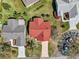 Aerial view highlighting the red roof, landscaped yard, and neighborhood, providing an overview of the property's location at 750 Evelynton Loop, The Villages, FL 32162