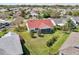 Bird's eye view showcases backyard screened-in porch, red roof, and meticulously manicured yard within the neighborhood at 750 Evelynton Loop, The Villages, FL 32162