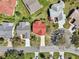 Overhead shot features red-roofed property, displaying landscaping, with a view into the neighborhood at 750 Evelynton Loop, The Villages, FL 32162