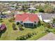 Aerial perspective reveals the backyard with screened in porch, complemented by the red roof and lush surroundings at 750 Evelynton Loop, The Villages, FL 32162