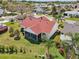 Aerial view of the backyard featuring a screened-in patio and lush green lawn at 750 Evelynton Loop, The Villages, FL 32162